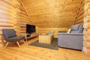 a living room with a couch and a television at Chalet des Noisetiers - Magnifique vue montagne in Cornimont