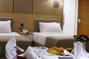a hotel room with two beds and a plate of food at Delmar Hotel Matrouh in Marsa Matruh
