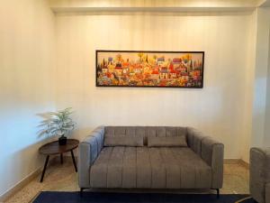 een woonkamer met een bank en een schilderij aan de muur bij Sleep at Saithai in Ban Sai Thai