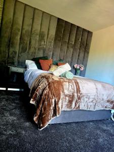 a bedroom with a bed with a wooden headboard at Petite retreat in Templepatrick