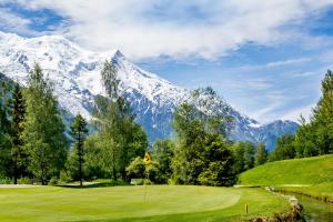 a golf course with a snow covered mountain in the background at Delice - City center Les Houches & Free Parking - By Cozee Rentals in Les Houches +17 photos