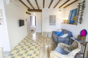a living room with a blue couch and chairs at HappyVila SUITE APARTMENTS in Villajoyosa