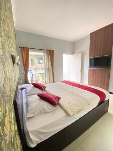 a bedroom with a large bed with red pillows at New Green Hill Hotel in Baratan