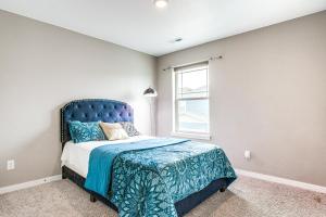 a bedroom with a bed with a blue headboard and a window at 17 Mi to Denver Zoo Family-Friendly Aurora Home in Aurora