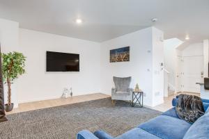 a living room with a blue couch and a tv at 17 Mi to Denver Zoo Family-Friendly Aurora Home in Aurora