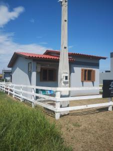a small house with a white fence in front of it at Hostel Osoriense in Osório
