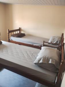 two twin beds in a room with at Hostel Osoriense in Osório