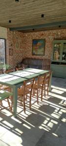 a green table and chairs in front of a brick building at Bilkarskata Kashta in Gorsko Slivovo