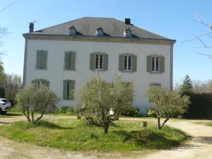 a large white house with trees in front of it at Villa Boulmia in Burlats