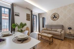 a living room with a couch and a table at Granaxperience Apartamentos La Maleta in Granada