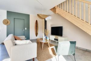 ein Wohnzimmer mit Sofa und Fernseher in der Unterkunft Belle maison pour 8 - 350m de la plage - Terrasse in La Guérinière