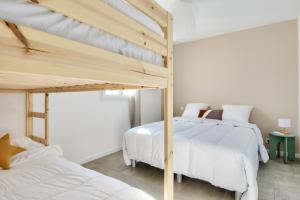 2 Etagenbetten in einem Zimmer mit weißen Wänden in der Unterkunft Belle maison pour 8 - 350m de la plage - Terrasse in La Guérinière