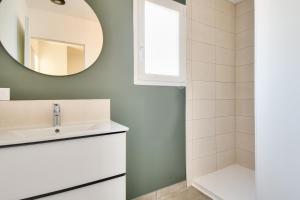 ein Badezimmer mit Waschbecken und Spiegel in der Unterkunft Belle maison pour 8 - 350m de la plage - Terrasse in La Guérinière + 11 Fotos