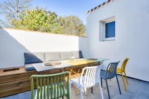 eine Terrasse mit Tisch und Stühlen auf einem Balkon in der Unterkunft Belle maison pour 8 - 350m de la plage - Terrasse in La Guérinière