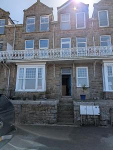 a brick house with a balcony on top of it at Bijou in St Ives