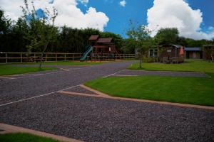 una entrada de grava con parque infantil y tobogán en The Lair, en Frome