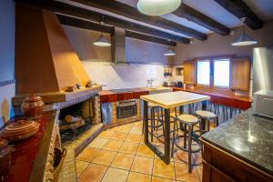 a large kitchen with a stove and a table in it at La Masia in Sant Pau dʼOrdal