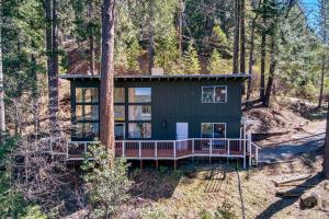 una casa nel bosco con un portico perimetrale di Glass Cabin Under the Pines | Hot Tub • Seclusion a Willow Valley