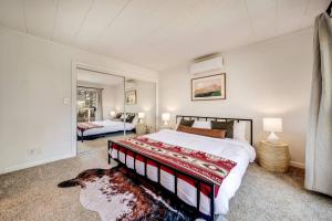 una camera da letto con un letto grande e uno specchio di Glass Cabin Under the Pines | Hot Tub • Seclusion a Willow Valley