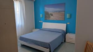 a bedroom with a bed with a blue wall at Appartamenti Vanin in Cavallino-Treporti