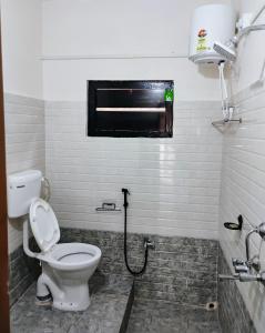a bathroom with a toilet and a window at Globetrotters homestay in Jorhāt
