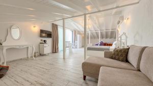 a living room with a couch and a bedroom at Cunda Nisa Otel in Cunda