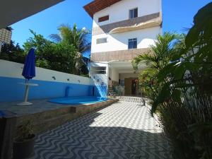 an external view of a building with a swimming pool at Quarto 3 quádruplo café da manhã em Pousada, Praia de Cabuçu BA in Saubara