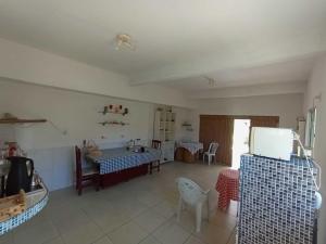 a living room with a table and a kitchen at Quarto 3 quádruplo café da manhã em Pousada, Praia de Cabuçu BA in Saubara