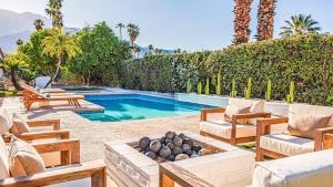einen Hinterhof mit einem Pool mit Stühlen und einem Tisch in der Unterkunft Luminous Home with Pool and Views in Palm Springs + 26 Fotos