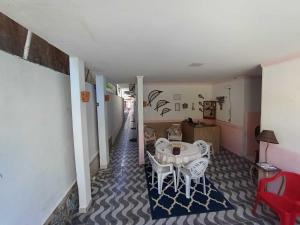 a hallway with a table and chairs in a house at Quarto 1 triplo café da manhã em Pousada, Praia de Cabuçu BA in Saubara
