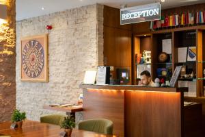 a man sitting at a counter in a restaurant at Hotel Bistrik City Center in Sarajevo