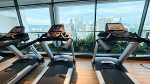 three cardio machines in a gym with a view of the city at Colony Service Suites Kuala Lumpur in Kuala Lumpur