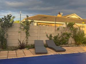 a backyard with two benches in front of a fence at 5 On Dana in Gqeberha