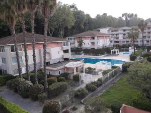 an aerial view of a resort with a swimming pool and palm trees at Appartement charmant à Cagnes-sur-Mer - 38 m² - Piscine in Cagnes-sur-Mer