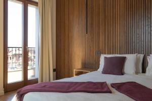 a bedroom with a large bed and a large window at Hotel Ristorante Da Politano in Boves