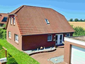a house with a red roof and a yard at Ferienhaus vor den Toren Greetsiels in Krummhörn