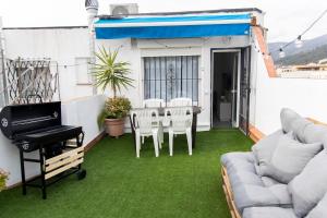 een patio met een grill en een tafel en stoelen bij Tossa Sunny in Tossa de Mar