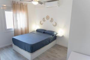 een slaapkamer met een bed met blauwe lakens en een raam bij Tossa Sunny in Tossa de Mar