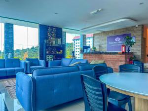 a waiting room with blue couches and tables at Tekoma Hotel & Hostel Cameron Highlands - FREE SHUTTLE SERVICE in Tanah Rata