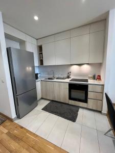 a kitchen with white cabinets and a stainless steel refrigerator at BW St Lui Apartment in Belgrade