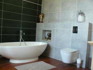 a bathroom with a white tub and a toilet at Villa Boulmia in Burlats +14 photos