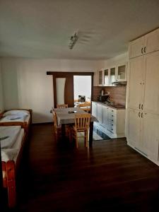 a room with a table and a kitchen with a bed at Relax Penzion U Adama in Dolná Tižina