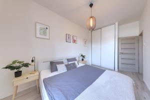 a white bedroom with a bed and a potted plant at Lovely 2-bedroom apartment in centre of Bratislava in Bratislava +11 photos