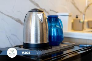 a silver appliance sitting on a counter with two blue vases at Makani Beach Flat Campas #308 - Frente Mar Alto Padrão in Tamandaré