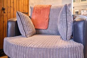 einem blaugestreiften Stuhl mit zwei Kissen darauf in der Unterkunft Host & Stay - Providence Cottage in Woolacombe