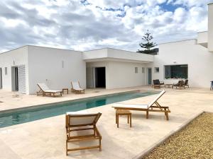 a swimming pool with chairs and a house at El Olivo Private Swimming Pool in Mojácar