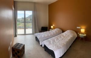 a bedroom with two beds and a large window at El Olivo Private Swimming Pool in Mojácar +41 photos