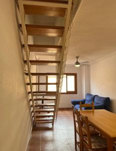 una scala a chiocciola in un soggiorno con tavolo e sedie di Duplex Frente Al Mar a San Pedro del Pinatar 1 altra foto