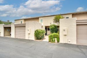a building with two garage doors and a driveway at Pet-Friendly Tucson Townhome with Pool Access! in Tucson
