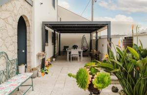 a patio with plants and a table on a building at Quartos para Férias - Apúlia in Apúlia